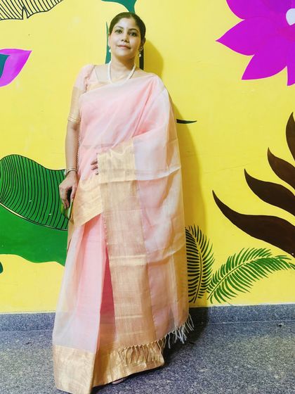 Standing against a vibrant, artistic wall, this pink and gold saree truly shines. This look is all about understated elegance, letting the beautiful fabric and simple draping speak for themselves.