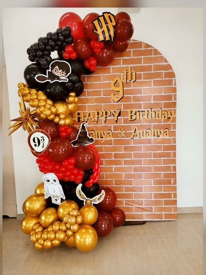 A straight-on view of the enchanting Harry Potter birthday backdrop. The rich colors of the balloon garland pop against the brick arch, creating the perfect magical entrance for party guests.