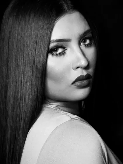 A profile shot that emphasizes the sleek hair and the strong lines of the makeup.