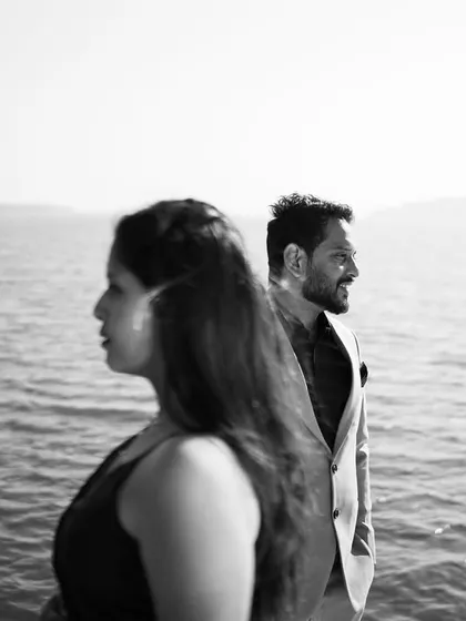 A moody black and white shot on the water. The composition creates a sense of story and contemplation, perfect for a cinematic pre-wedding album.
