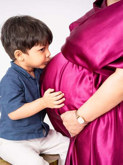 A big brother giving his mom's baby bump a sweet kiss. This was taken a year before the new baby arrived, showing the journey of becoming a big brother.