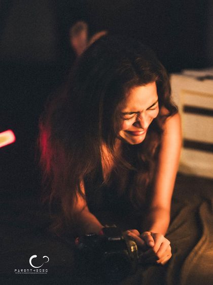 A moment of genuine laughter, even in a low-light, intimate setting. This shot captures the joy and release that can come from a creative and comfortable photoshoot.