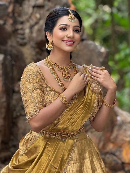 A beautiful portrait of the model, showcasing her complete look in the golden half-saree.