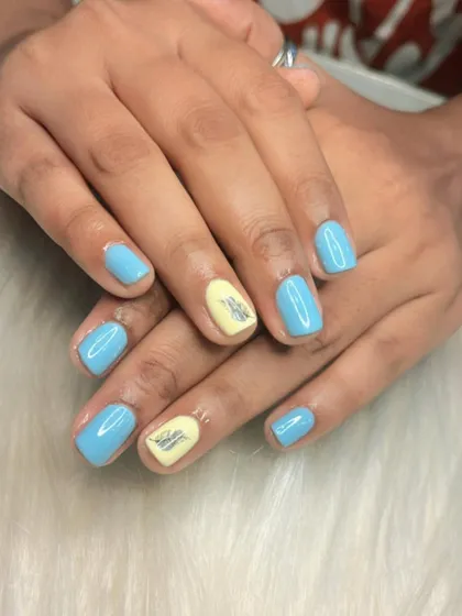 A cute and personalized manicure with a sky blue base and yellow accent nails featuring a small logo. I can add custom decals or hand-painted logos to any set.
