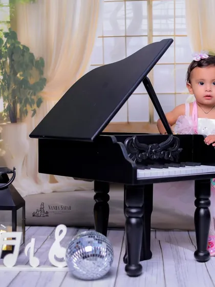 Our 'Mini Musician' theme is perfect for little princesses too. Dressed in a lovely pink gown, she looks right at home next to the piano, surrounded by elegant props like lanterns and a disco ball.