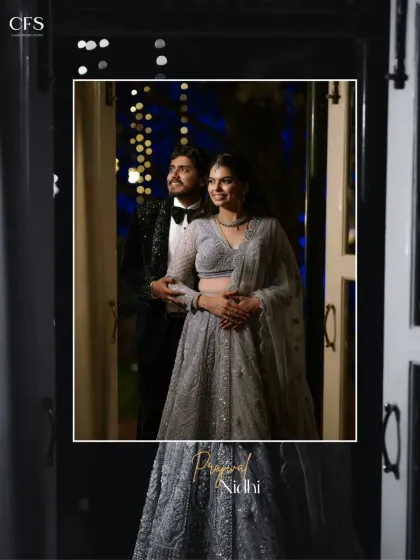 A glamorous evening portrait of a couple dressed in stunning reception wear. The dark, moody lighting with bokeh highlights creates a feeling of romance and sophistication.