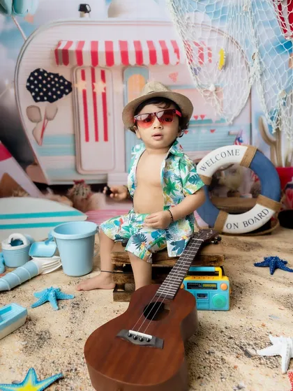 Strumming the ukulele at the beach. I love adding interactive props to my themed sessions.