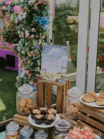 A closer look at our custom "Bakery Cart" setup. Jars filled with cookies and muffins are displayed on rustic wooden crates, creating an inviting and charming dessert station for a daytime event.