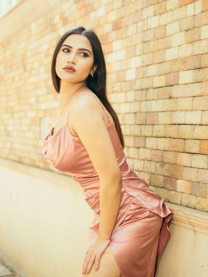 Using a textured brick wall and the strong midday sun to create a warm, high-contrast portrait. This is a great example of how I find and use simple, effective backdrops for street photography.