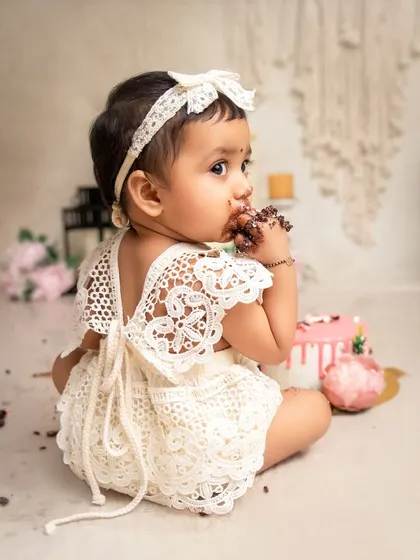 A close-up of the cake smash action. This little one is getting right into her first taste of birthday cake, a classic and fun moment to capture.