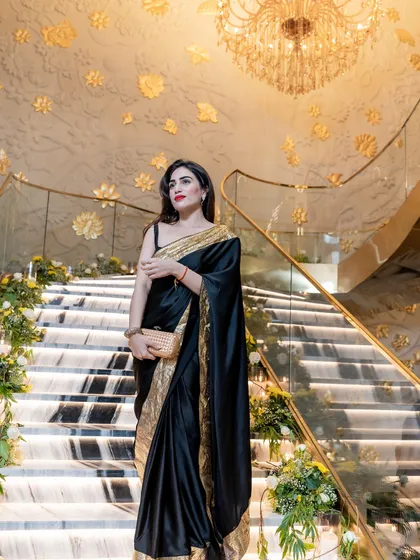 For a glamorous reception, I designed this black satin saree with a gold border. It’s a classic combination that never fails to make a statement.