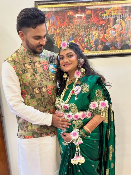 The happy couple at their baby shower. The mom-to-be is glowing in her green saree and beautiful floral jewelry.
