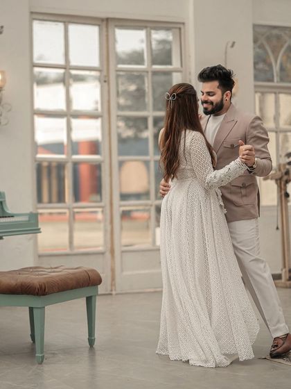 A sweet, romantic dance in a beautiful, sunlit room. This image captures a candid moment of joy and movement, with the piano in the background adding a touch of classic romance.