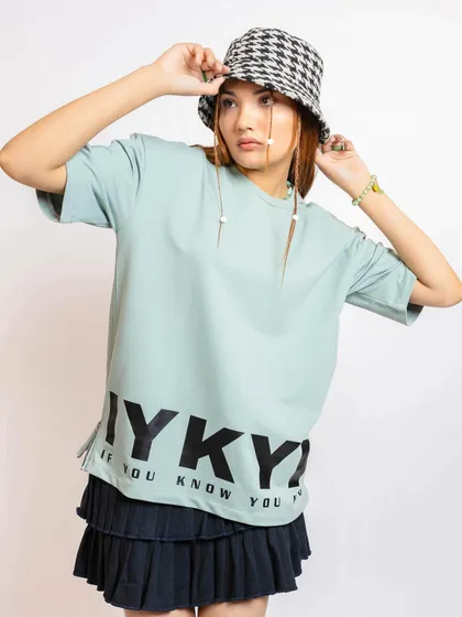 Here, I styled a mint green graphic tee with a tiered black mini skirt and a houndstooth bucket hat. This look mixes classic streetwear elements with a feminine twist.