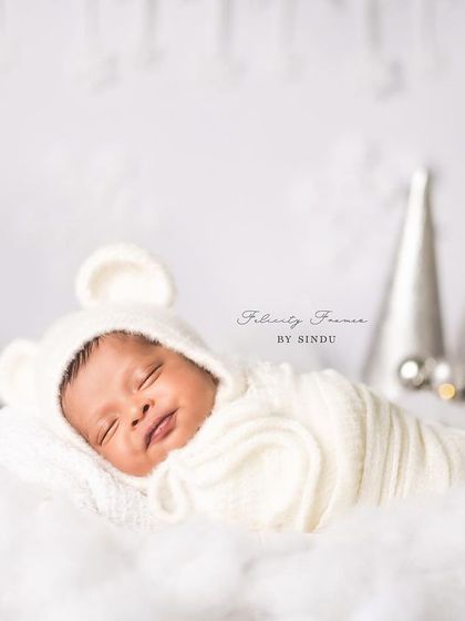 A tiny bear cub fast asleep. The soft, knitted outfit and bonnet keep this newborn snug and adorable, showcasing the peacefulness of those first few days of life.