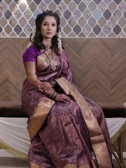A regal look in a purple saree. The makeup is kept soft and elegant to balance the richness of the traditional attire.