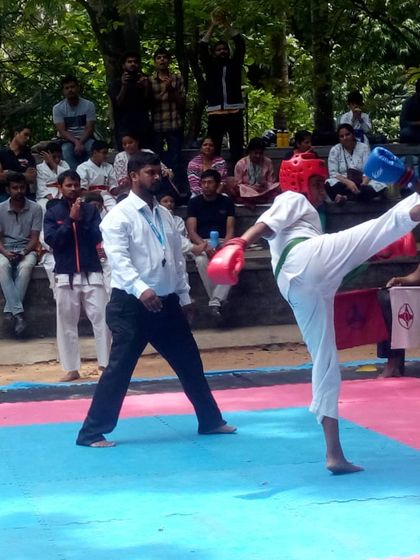 A high kick (jodan geri) is executed during a tournament. This demonstrates the flexibility and power we develop through training.