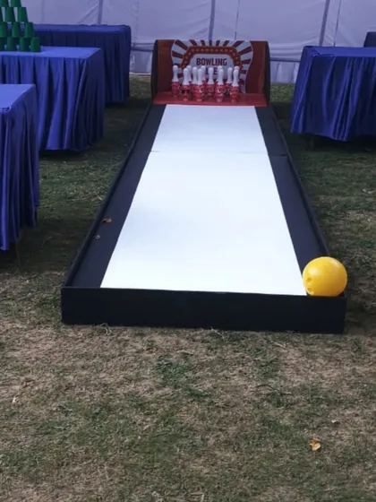 A clear shot of the mini bowling alley setup on grass for a corporate event. It's compact, easy to set up, and provides all the fun of real bowling.