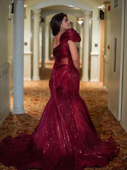 A final look at the red sculpted gown, showing its full length from the back. The train flows beautifully, creating a dramatic and unforgettable silhouette.
