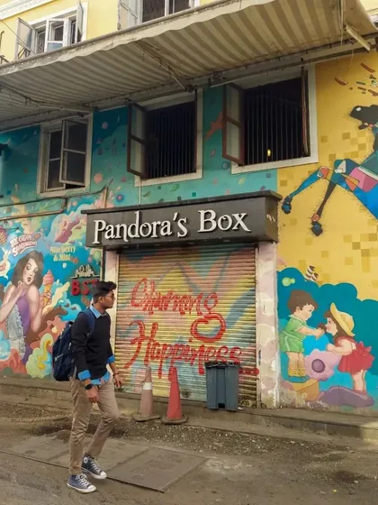 The colorful and playful mural on the shutters of "Pandora's Box" in the Kala Ghoda area. The art, featuring children and bright colors, adds to the creative atmosphere of the neighborhood.