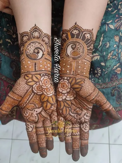 A beautiful design for the bride's mom, featuring peacock and lotus mandalas on the back of the hands, surrounded by floral details.