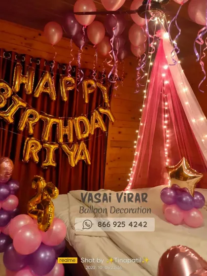 We love creating romantic surprises! This bedroom decoration features a dreamy pink canopy with fairy lights over the bed, surrounded by pink and purple balloons. The personalized "Happy Birthday Riya" foil balloons make the celebration feel extra special.