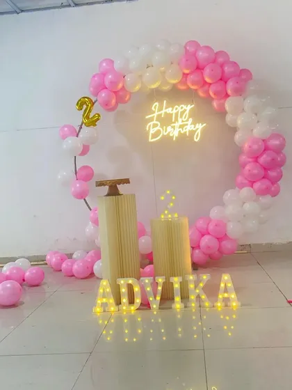 A simple and pretty pink and white circular balloon arch for a second birthday. This clean setup is perfect for a small party at home.
