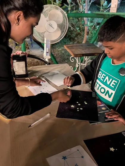 A child creates their own glow in the dark constellation art. This hands on craft lets kids take a piece of the night sky home with them.