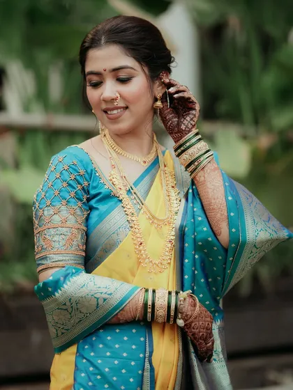 This bride's look for her Maharashtrian wedding features a beautiful yellow and turquoise saree, complemented by soft, elegant makeup.