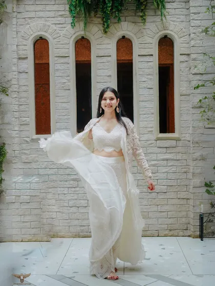 A beautiful solo shot of the bride-to-be, her flowing white outfit creating a sense of movement and grace. The heritage-style building in the background adds a touch of timeless elegance to this pre-wedding portrait.
