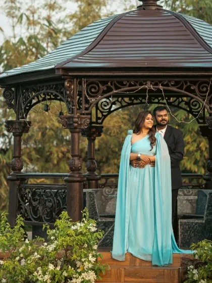 A serene and elegant look with this sky blue gown. It features flowing cape-like sleeves that create a soft and ethereal silhouette, perfect for a garden or park setting.