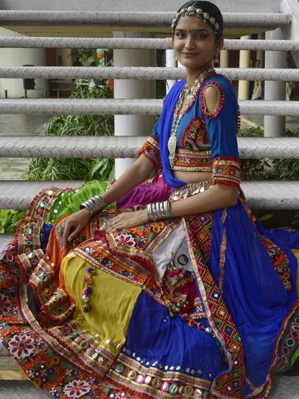 A full-length seated pose showing the beautiful spread of this colorful lehenga. This is a perfect outfit for a queen.