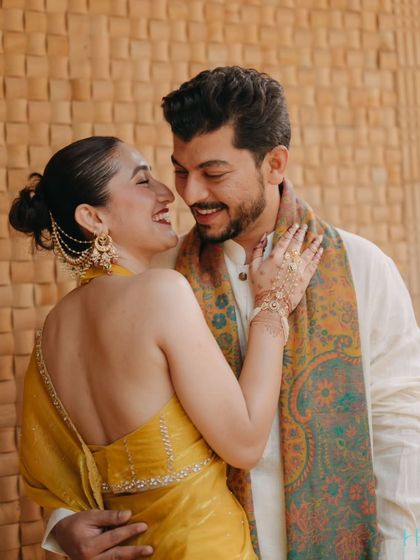 An intimate close-up of the couple, their faces close together, sharing a laugh during their sun-drenched Haldi ceremony.