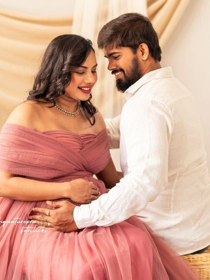 A sweet, seated portrait where the couple shares a private smile, creating an intimate and natural feel.