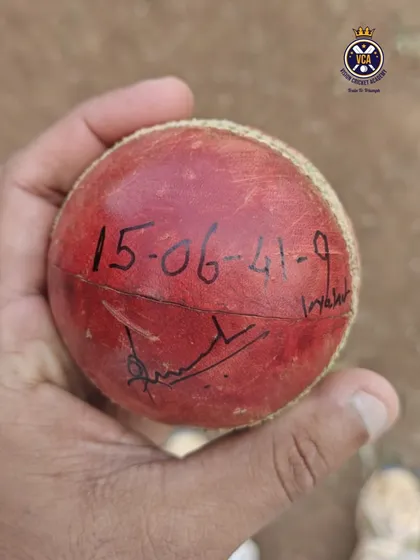 The match ball that tells the story. A close-up of the cricket ball with the figures 15-06-41-9 written on it, commemorating coach Shreenesh Shah's 9-wicket haul in a single innings.