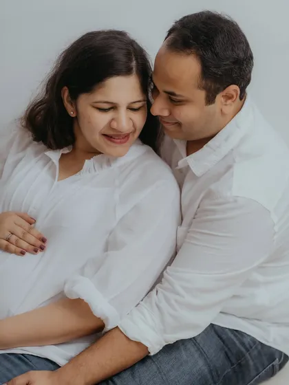 A tender moment where the couple's focus is on the baby bump. This image beautifully captures the shared wonder and love for their soon-to-arrive baby in a natural, unposed way.