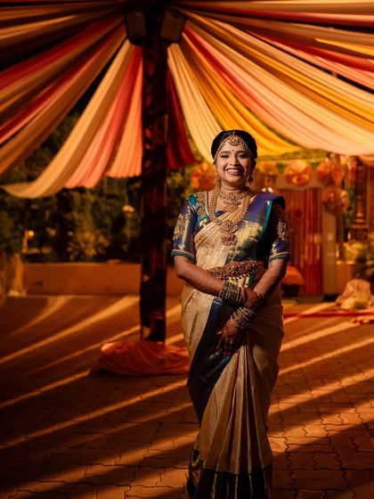 A wide shot showing the bride against a beautifully decorated backdrop, her look shining.