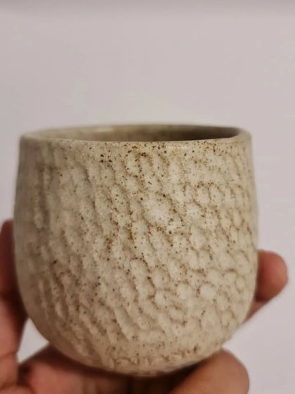 Another view of the textured ceramic candle holder. The carved surface creates a beautiful play of light and shadow when a candle is lit inside.