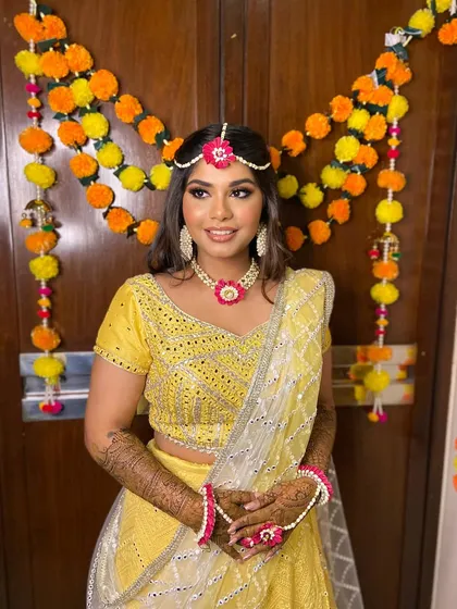 The full mehendi look for Simran, set against a traditional marigold backdrop.