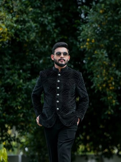 The full view of this groom's modern engagement outfit. The tailored jacket and clean lines create a very sharp look.