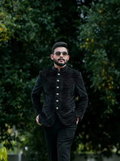 The full view of this groom's modern engagement outfit. The tailored jacket and clean lines create a very sharp look.