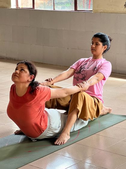 Two students working together in a partner-assisted stretch. This helps to safely increase flexibility and understand the mechanics of the posture from a different perspective.