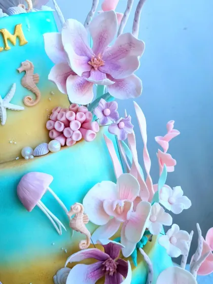 A close-up of the intricate sugar flowers and fondant sea creatures on the mermaid cake.