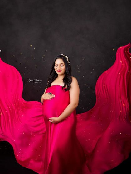Another take on the fabric toss, with golden sparkles added for a touch of magic. The mom-to-be looks like a queen in her flowing red gown.