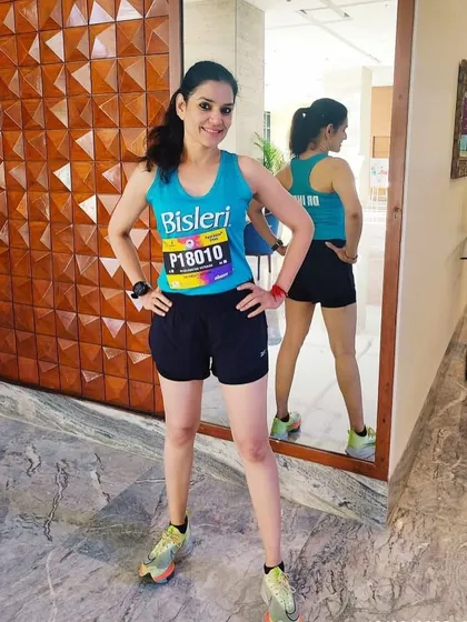 Ready to race in her Bisleri team gear. This photo shows Dr. Indu before a marathon, highlighting her professional approach and readiness to compete.