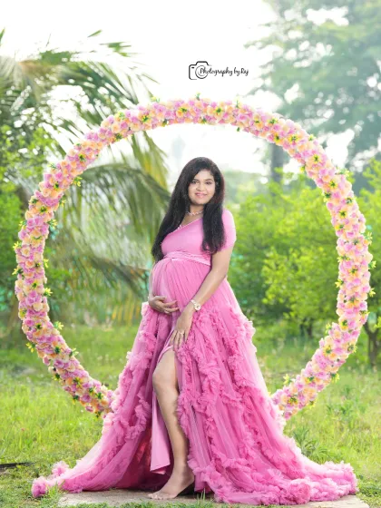 A lovely portrait using our circular floral prop. The mother-to-be looks radiant in a pink ruffled gown, creating a beautiful composition.
