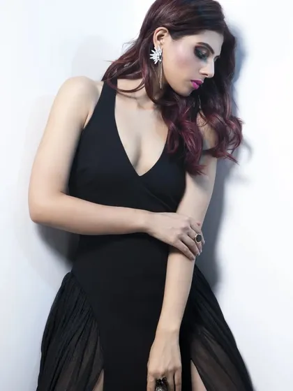Every woman needs a classic black gown. This one features a plunging neckline and a double thigh-high slit with sheer panels, creating a look that is both elegant and daring.