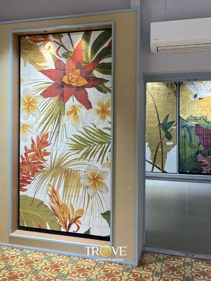This showroom display features two distinct custom murals. One is a vibrant, tropical floral design, while the other depicts hummingbirds against a golden backdrop, demonstrating the wide range of artistic styles I can produce on tile to match any interior theme.