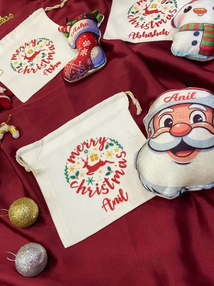 A flat lay of our personalised Christmas plush ornaments and matching goodie bags.