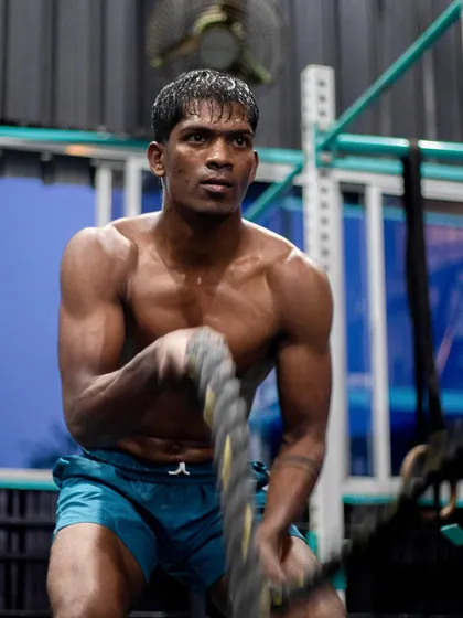 Combat sports require a powerful engine. Here, an athlete builds explosive power and cardiovascular endurance with battle ropes, a core part of our strength and conditioning program that supports your martial arts training.